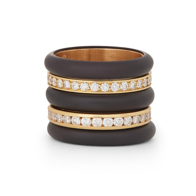 Stackable ring featuring a dark band with gold accents and crystals